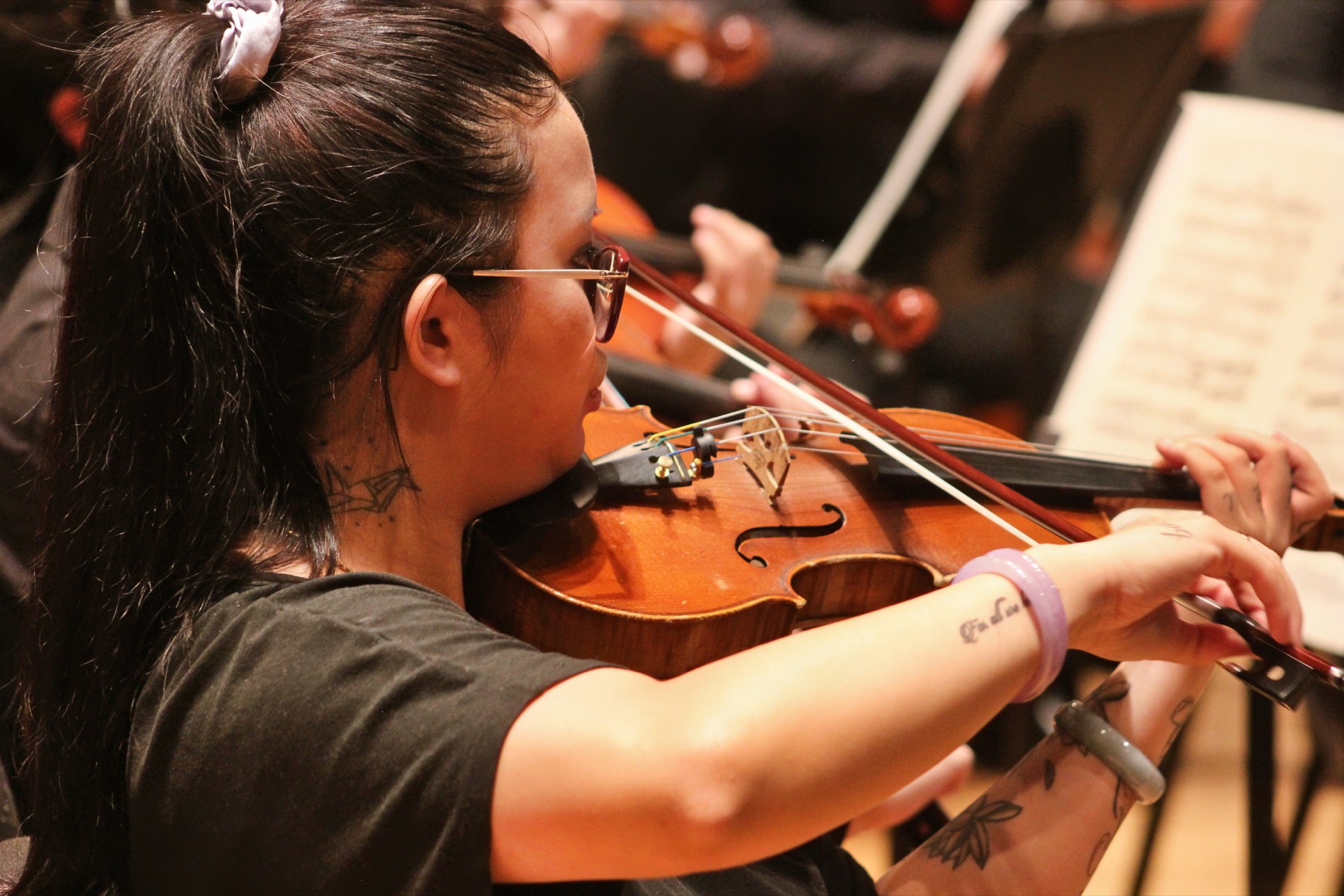 A violinist performing with an orchestra